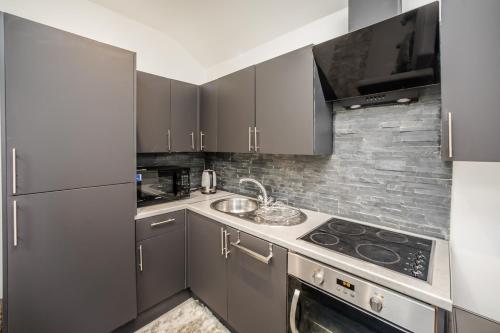 a kitchen with stainless steel appliances and a sink at Cottage hide-out in Kirkheaton