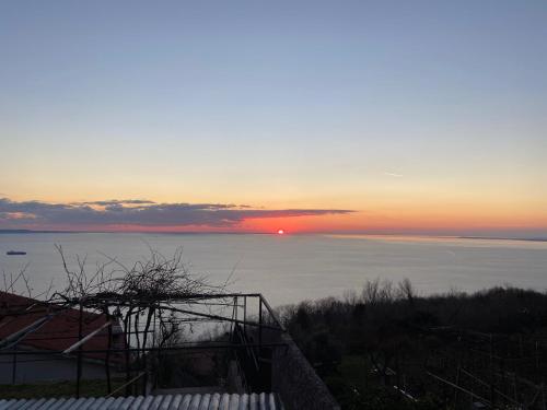 a sunset over the water with the sun in the sky at Casa Contovello in Trieste