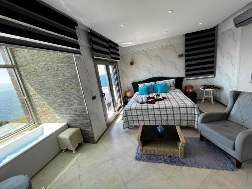 a bedroom with a bed and a couch and a room with a couch at Mavi Panorama Villa in Cesme