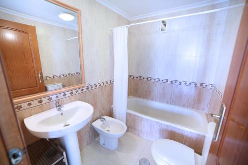 a bathroom with a sink and a toilet and a tub at Las Gemelas Apartments in La Manga del Mar Menor