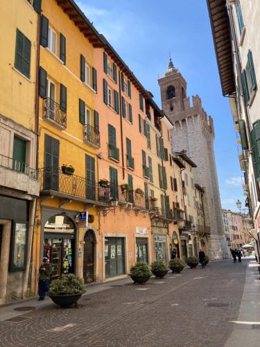 una calle de la ciudad con edificios y una torre del reloj en Casa Roveglia, en Brescia