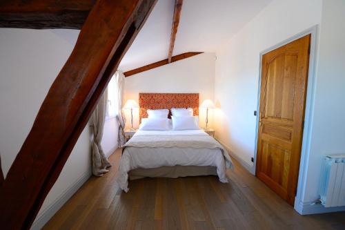 a bedroom with a bed with white sheets and a wooden door at Alexandre Design Smart Flat in Bordeaux