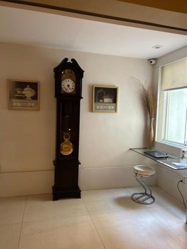 a grandfather clock in a corner of a room at Hotel Petit Village Icaraí in Niterói