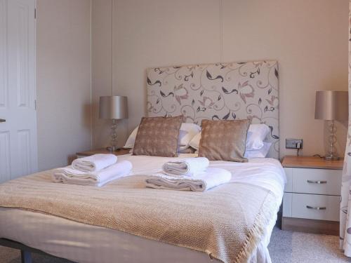 a bedroom with a bed with towels on it at Tiptoes Lodge in Carnforth