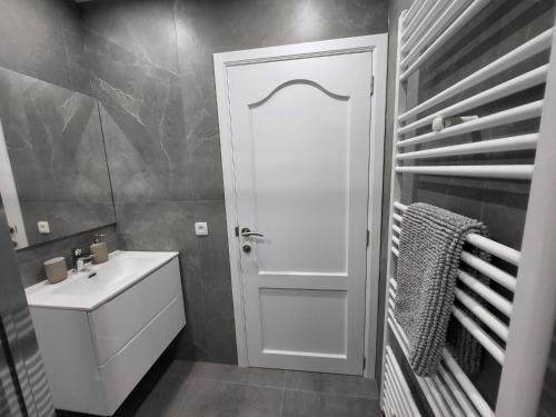 a bathroom with a white door and a sink at Eden's private room - European Quarter in Brussels
