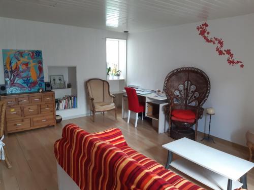 ein Wohnzimmer mit einem Sofa, einem Tisch und Stühlen in der Unterkunft Maison de paludier in Guérande