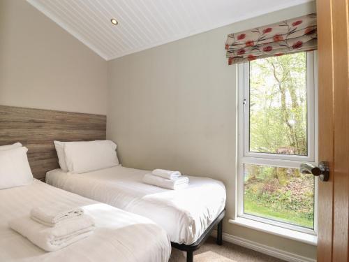 two beds in a room with a window at 18 Crake Valley in Ulverston