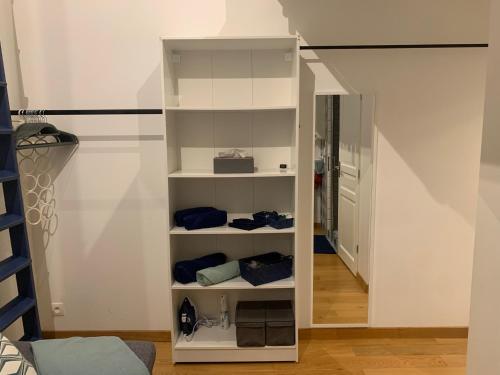 a white book shelf in a room with a hallway at Tiny House Sedan in Sedan