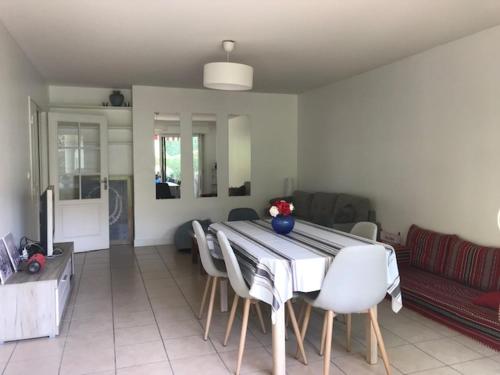 un salon avec une table, des chaises et un canapé dans l'établissement T3, jardin privatif, 2 chambres, Côte Basque (Anglet), à Anglet