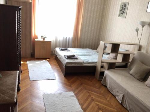um quarto com 2 camas, um sofá e uma janela em Cozy flat at Stadionok M station em Budapeste