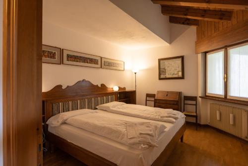 a bedroom with a large bed with a wooden headboard at Casa Marmarole in Borca di Cadore