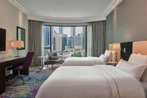 a hotel room with two beds and a large window at The Westin Kuala Lumpur in Kuala Lumpur