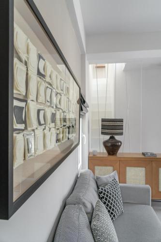 a living room with a couch and a wall of plates at Utopia Eco Retreat in Skiathos Town