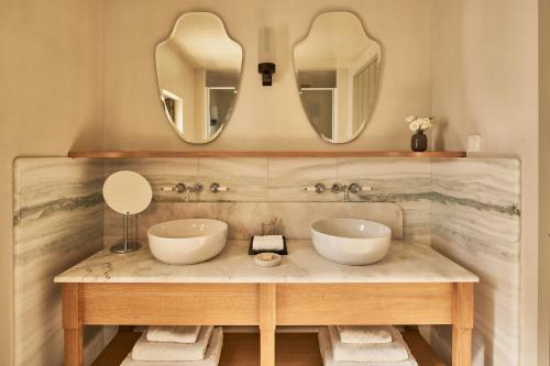 La salle de bains est pourvue de 2 lavabos et de 2 miroirs. dans l'établissement Cosme, a Luxury Collection Resort, Paros, à Náoussa
