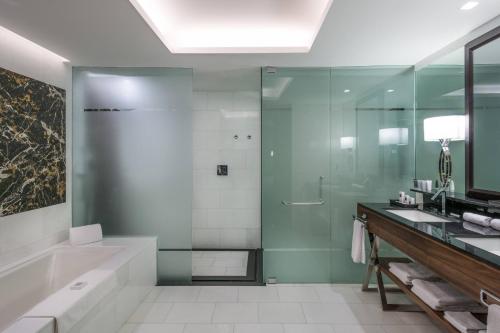 a bathroom with a shower and a tub and a sink at JW Marriott Hotel Santo Domingo in Santo Domingo