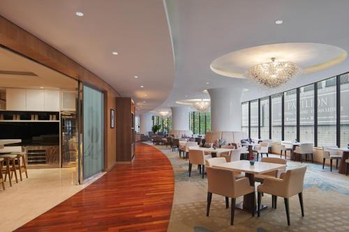 een restaurant met tafels en stoelen en een piano bij The Westin Kuala Lumpur in Kuala Lumpur