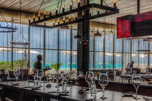a dining room with tables and chairs and large windows at JW Marriott Hotel Santo Domingo in Santo Domingo