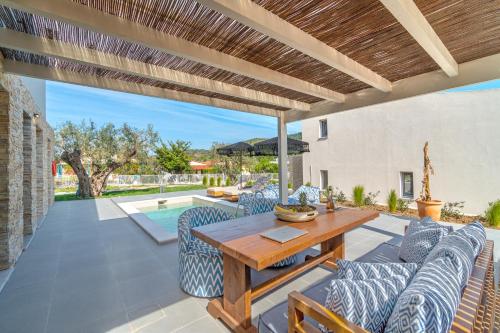 an outdoor patio with a wooden table and chairs at Utopia Eco Retreat in Skiathos