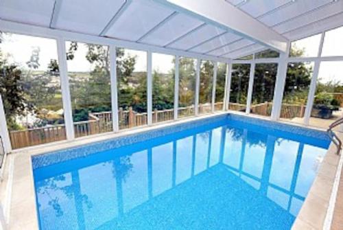 a swimming pool with blue water in a house at Luxury House, SeaViews, En-Suites & Private Pool in Saundersfoot