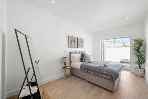 a white bedroom with a bed and a window at Stunning Scandi Gem in Bristol - Sleeps 6 in Bristol