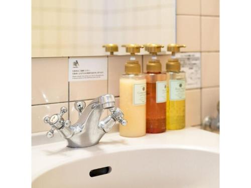 a bathroom sink with four bottles of soap at Plaza Hotel Premier - Vacation STAY 40093v in Fukuoka