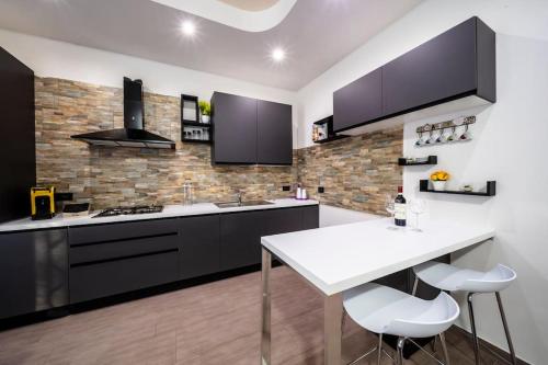 a kitchen with black cabinets and a white counter top at Galì Holidays Casa Vacanze in Acquedolci