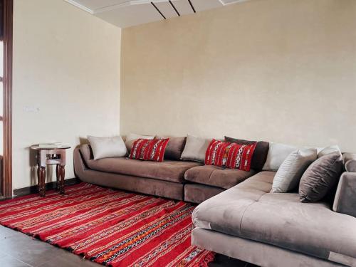 a living room with a couch and a red rug at Dar Sakina with Private Pool in Oulad Zenati