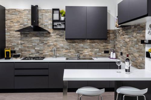 a kitchen with black cabinets and a white table at Galì Holidays Casa Vacanze in Acquedolci