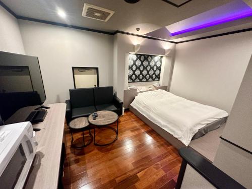 Habitación pequeña con cama y sofá en grandir ｸﾞﾗﾝﾃﾞｨｰﾙ-Adult Only-, en Yokohama