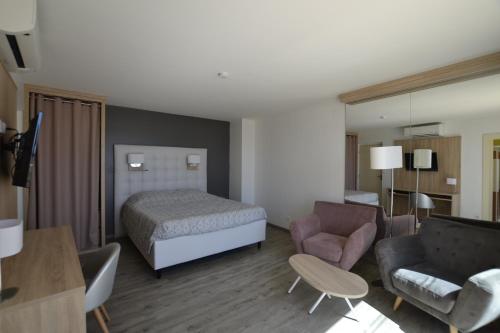 une chambre d'hôtel avec un lit et un salon dans l'établissement Studio Ève Résidence Naturiste Le Jardin D'Eden, au Cap d'Agde
