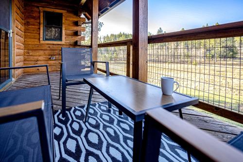 eine Veranda mit einem Tisch und Stühlen auf einer Hütte in der Unterkunft Tranquility on White Tail Road in Deadwood