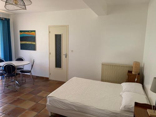 una camera con letto, tavolo e sedie di Casa Rossa Solenzara a Sari Solenzara
