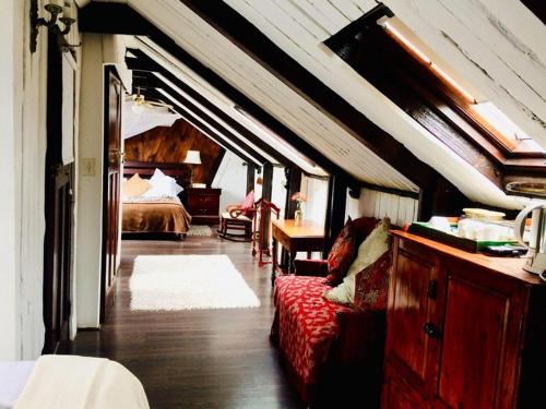 a bedroom with a bed and a red couch in a room at Harfield Guest Villa in Cape Town