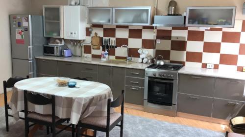 a kitchen with a table and a stove and a refrigerator at House of Grace in Reni