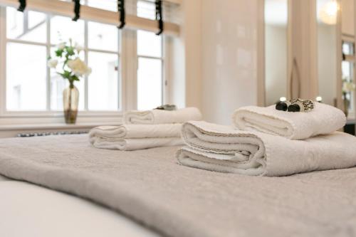 a pile of towels sitting on top of a bed at Hidden gem in Covent Garden in London