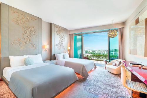 a hotel room with two beds and a window at W Singapore - Sentosa Cove in Singapore