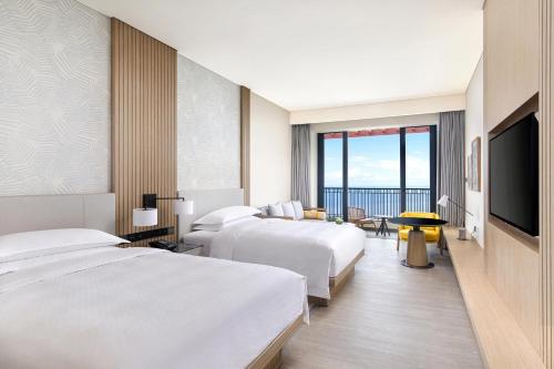 Habitación de hotel con 2 camas y TV de pantalla plana. en Four Points by Sheraton Wuchuan, Loong Bay, en Wuchuan