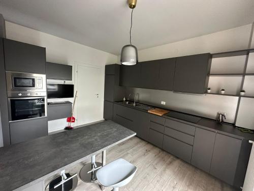 a kitchen with gray cabinets and a white chair at Ca Re Rovereto in Pordenone