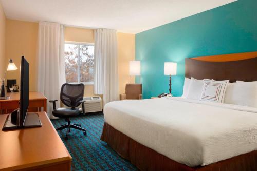 um quarto de hotel com uma cama e uma secretária com um computador em Fairfield Inn & Suites Minneapolis St. Paul/Roseville em Roseville