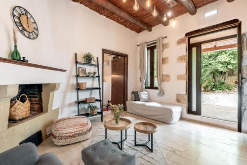 a living room with a fireplace and a couch at Joel Living Collection - Rustic Villa in Áptera