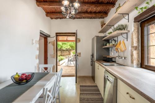 a kitchen with a large counter and a dining table at Joel Living Collection - Rustic Villa in Áptera