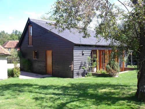uma casa a preto e branco com um quintal em Wilderness B&B 3 Self Contained Rooms Nr Sissinghurst em Headcorn