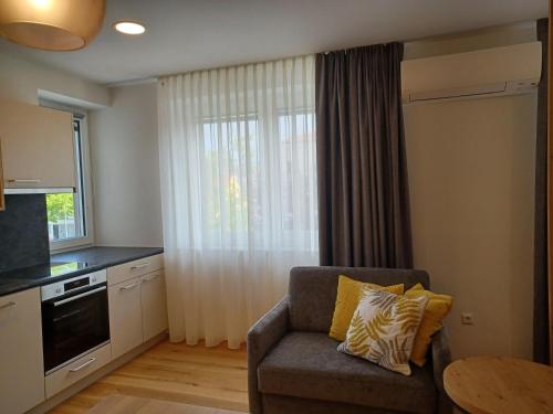 a living room with a chair and a table and a kitchen at Weingut Königshofer in Neusiedl am See