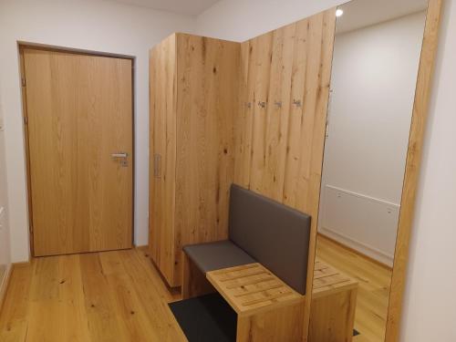 a room with a chair and a wooden door at Weingut Königshofer in Neusiedl am See
