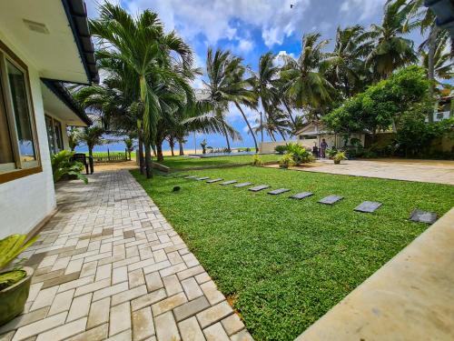 trawnik z kamieniami krokowymi przed domem w obiekcie Star Beach Guest House w Negombo