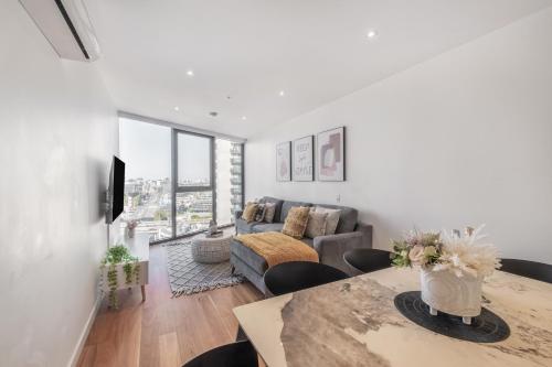 ein Wohnzimmer mit einem Tisch und einem Sofa in der Unterkunft Mega Style Apartments Bella in Melbourne