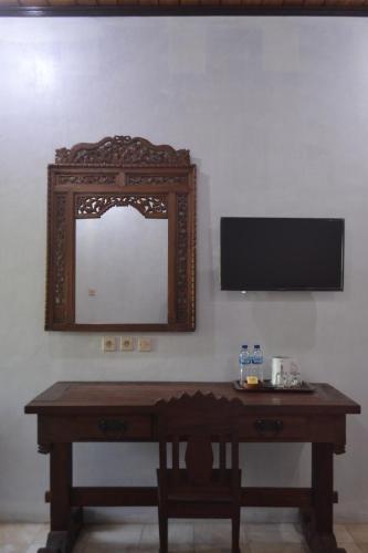 a mirror on a wall next to a wooden table at hotel batukaras kalaras in Batukaras