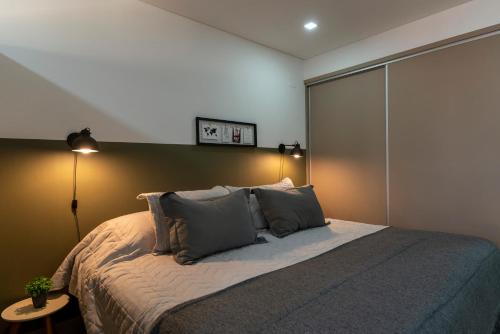 1 dormitorio con 1 cama grande y 2 almohadas en Departamento céntrico II con estacionamiento gratis en San Salvador de Jujuy