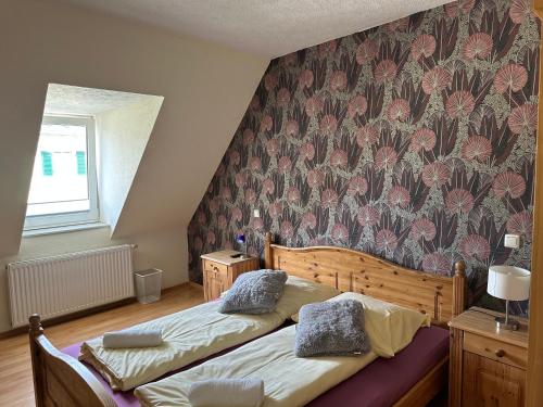 a bedroom with two beds with a floral wallpaper at Hotel My My in Lahnstein