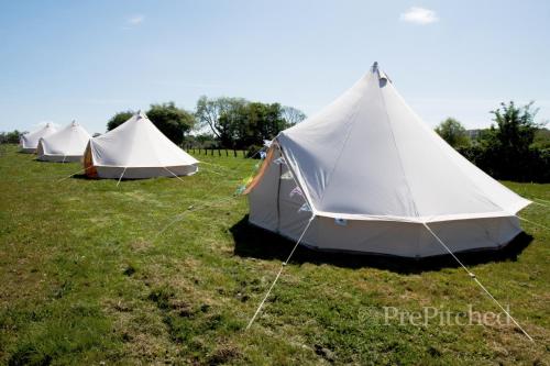 a row of tents sitting in a field at Acre & Shelter Yurt and Bell Tents at Bramham Horse Trials in Leeds